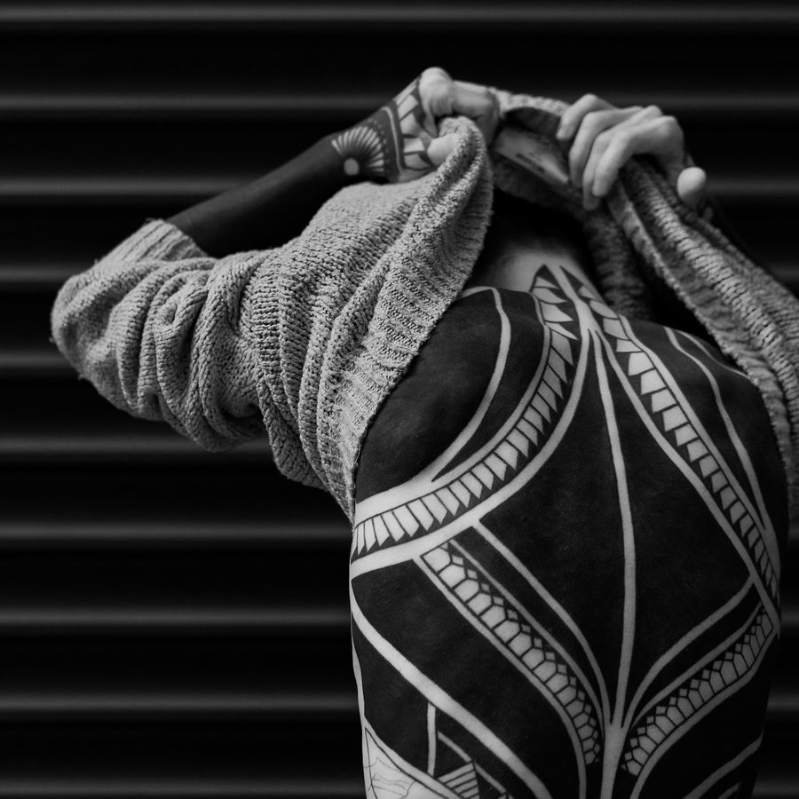 Blackwork: flächiges schwarzes Muster mit grafischen Bändern über den ganzen Rücken